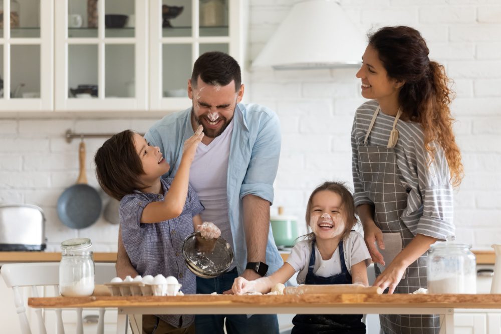 A family with young children baking together.