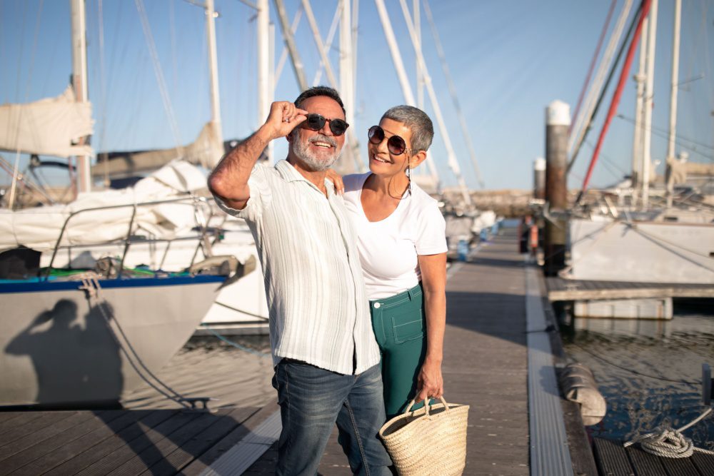 A couple posing on a marina pier.