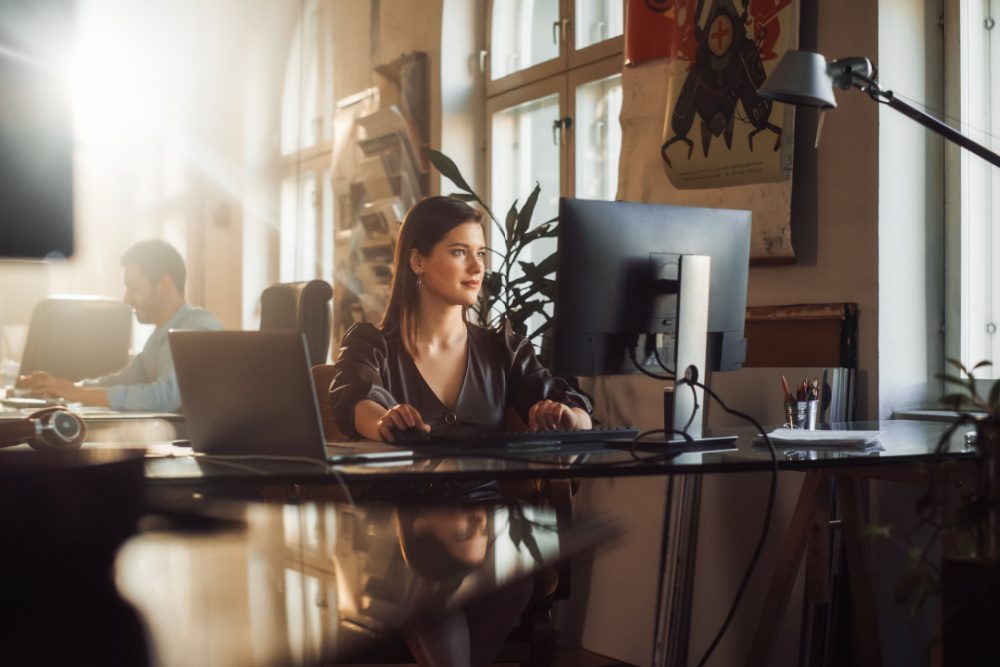 A woman using a computer in an office.